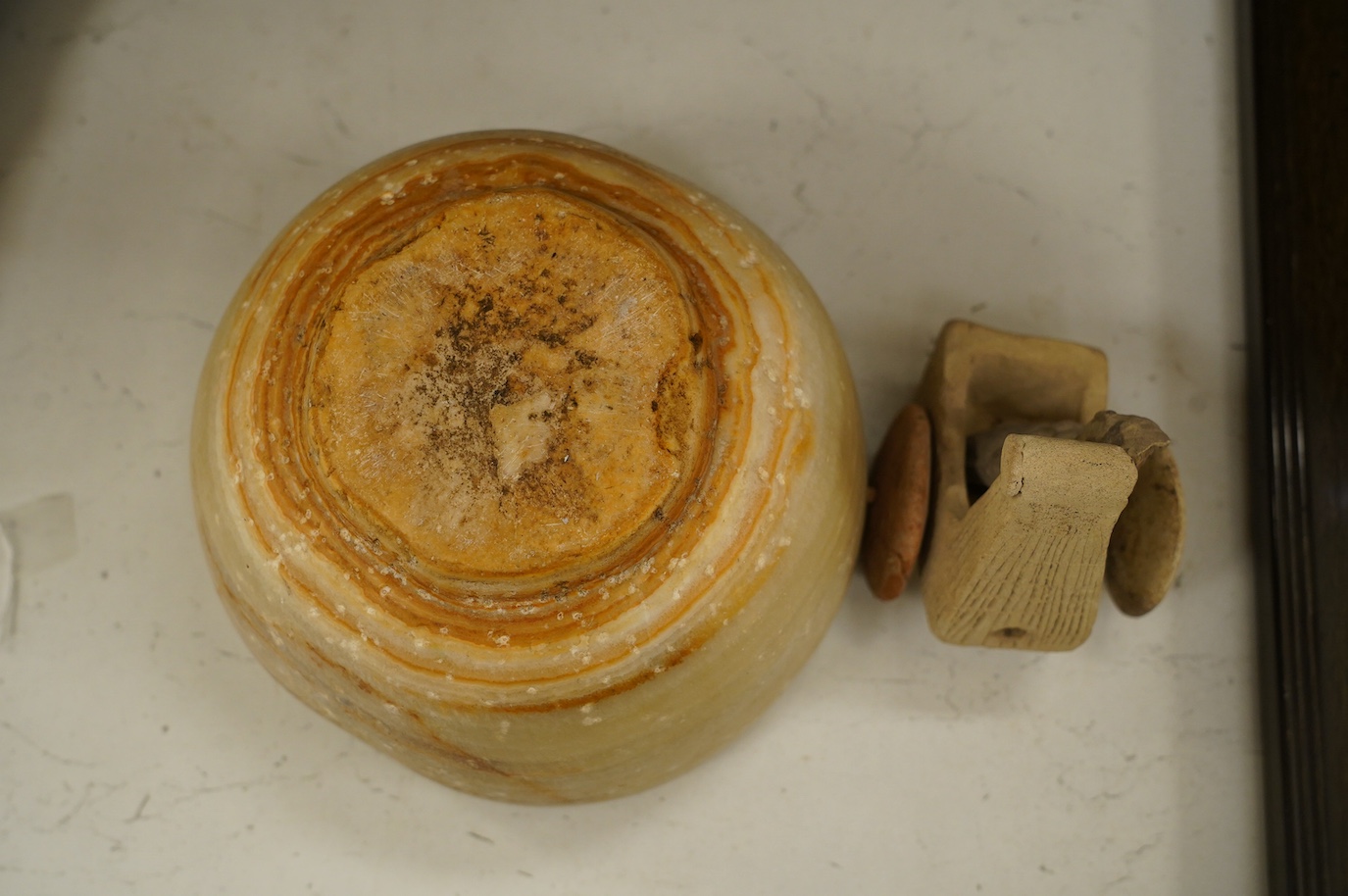 An alabaster mortar, possibly Ancient Egyptian, 17cm diameter, the handles ground off and a terracotta figure with chariot, possibly Mesopotamian. Condition - fair, restoration to chariot